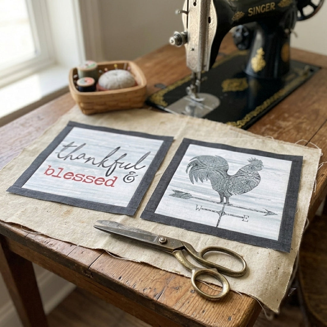 Fussy-cut squares from the Farm Sweet Farm squares panel with dark border on a vintage Singer sewing table with scissors and pin cushion