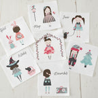 Girls calendar quilt panel blocks April May June October November December seasonal characters pink aqua white fabric on whitewashed wood