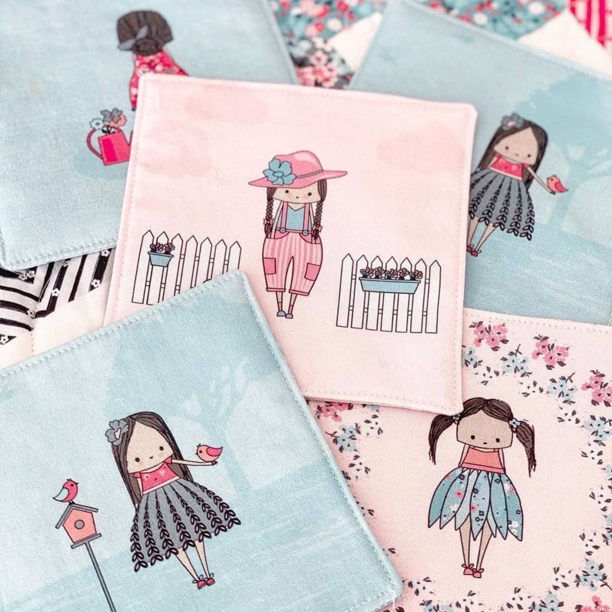 Abbie's Garden quilt blocks with flowers and birds on aqua and pink backgrounds