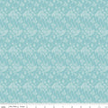 Teal fabric with white floral pattern, ruler at the bottom for scale.
