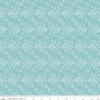 Teal fabric with white floral pattern, ruler at the bottom for scale.