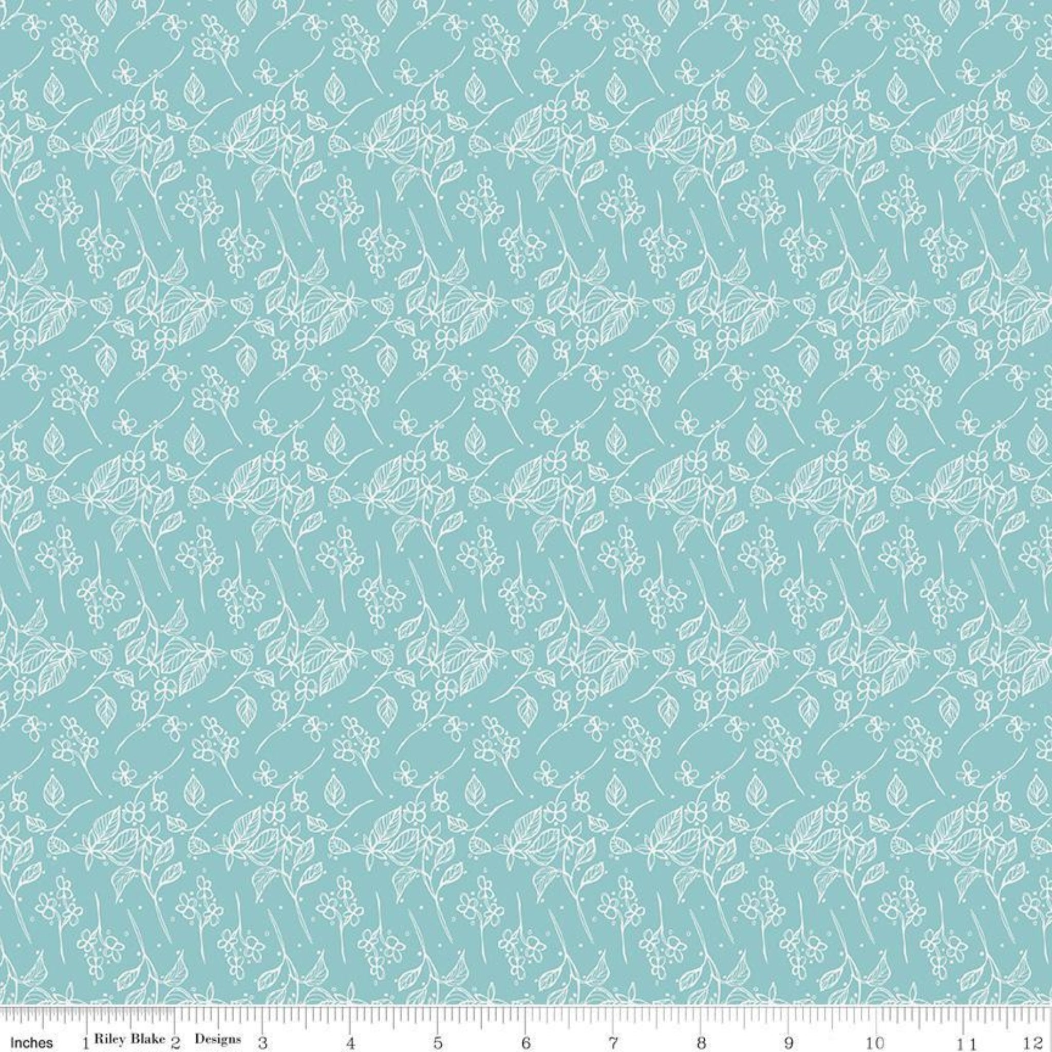 Teal fabric with white floral pattern, ruler at the bottom for scale.