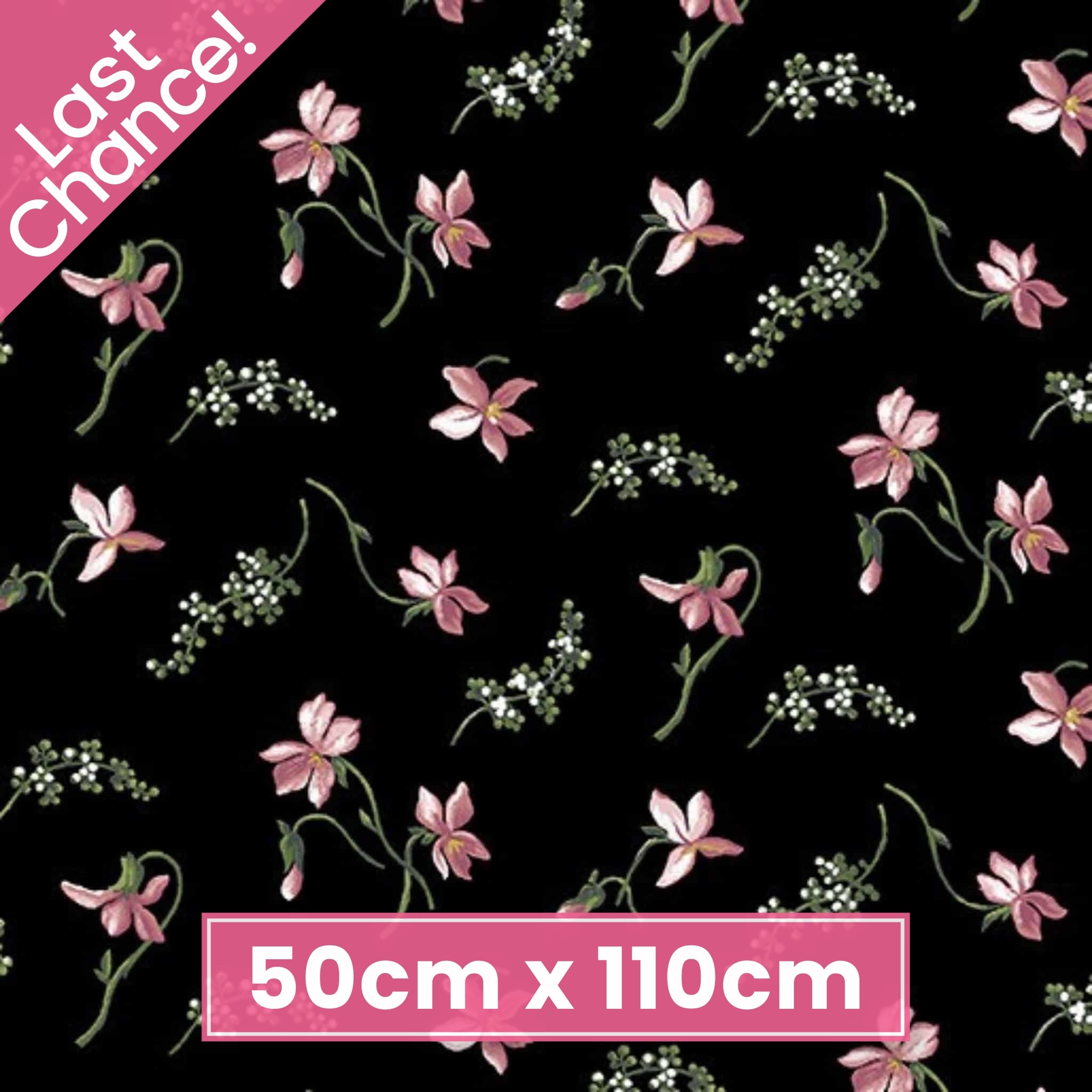 Quilting fabric with small, scattered coral-pink magnolia blossoms on a black background