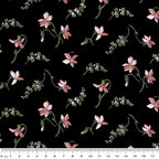 Quilting fabric with small, scattered coral-pink magnolia blossoms on a black background