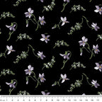 Quilting fabric with small, scattered purple magnolia blossoms on a black background
