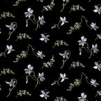 Quilting fabric with small, scattered purple magnolia blossoms on a black background