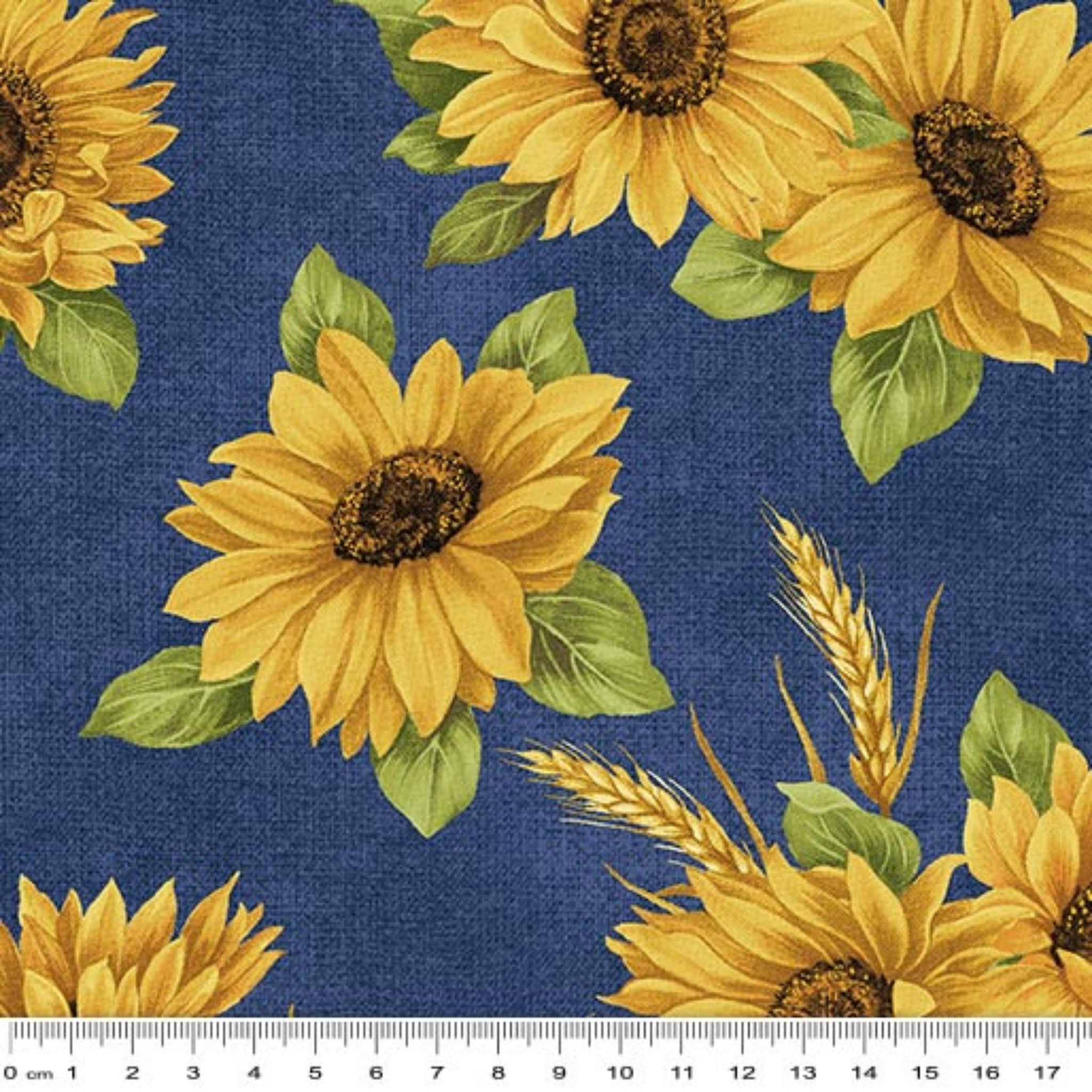 Quilting fabric with bright yellow sunflowers and wheat sheaves on a deep indigo blue background