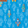 Royal blue fabric with a repeating pattern of colourful and outlined rockets that glow in the dark