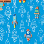 Royal blue fabric with a repeating pattern of colourful and outlined rockets that glow in the dark