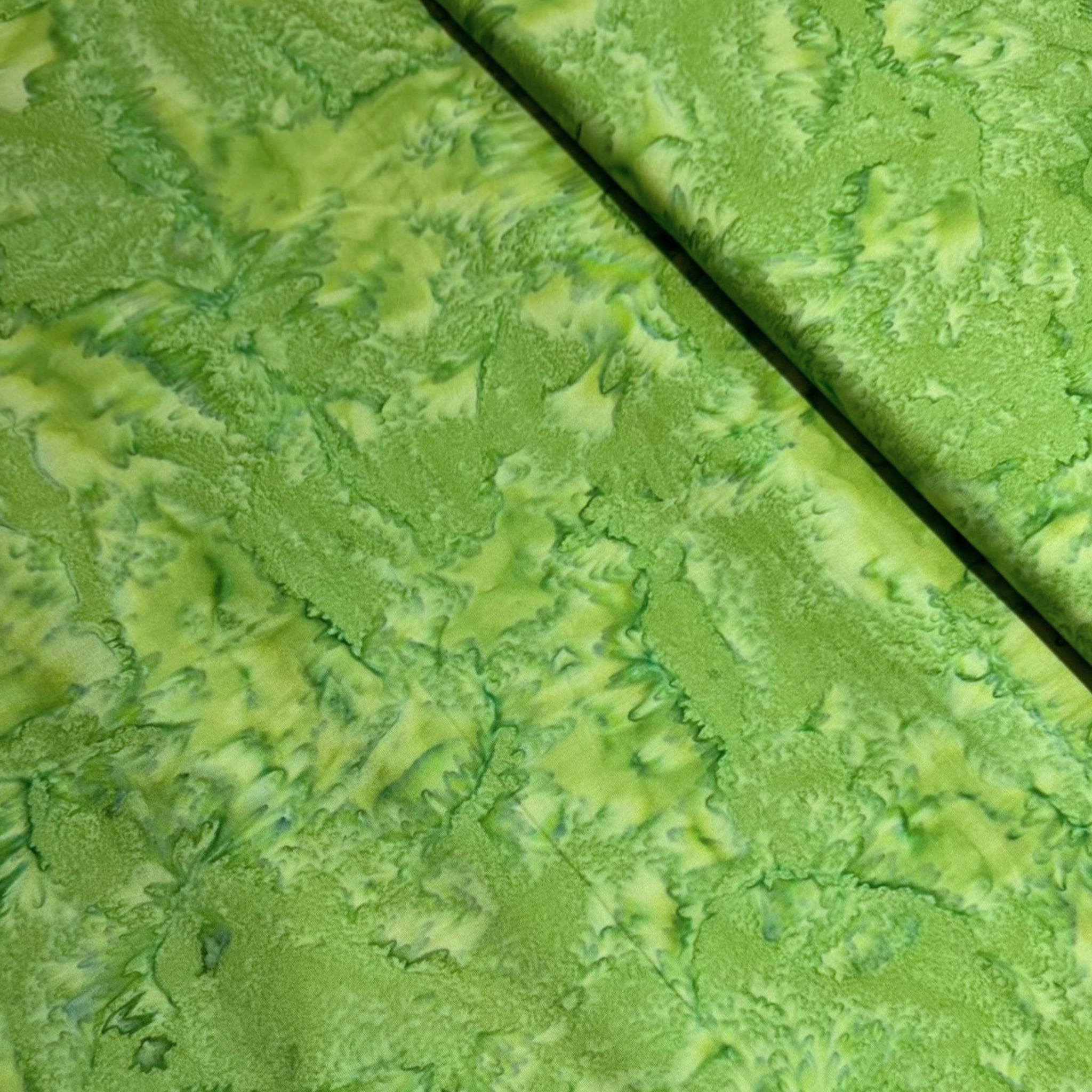 Bright kelly bamboo green mottled batik blender fabric with lime and forest green undertones for quilt backgrounds sashing and scrappy batik quilts