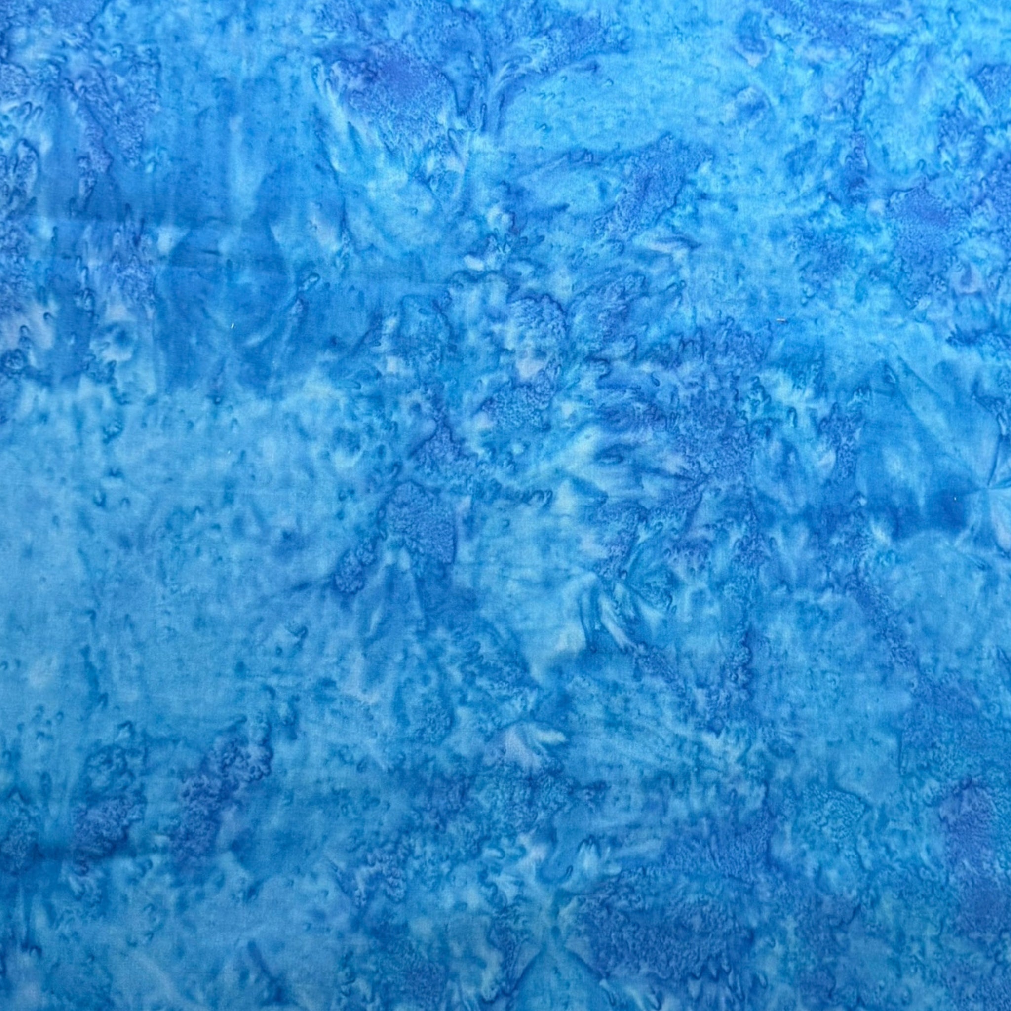 Vivid Bahama blue mottled batik blender fabric with sky blue and cobalt undertones for quilt backgrounds sashing and scrappy batik quilts