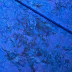 Deep violet blue mottled batik blender fabric with teal purple and navy undertones for quilt backgrounds sashing and scrappy batik quilts