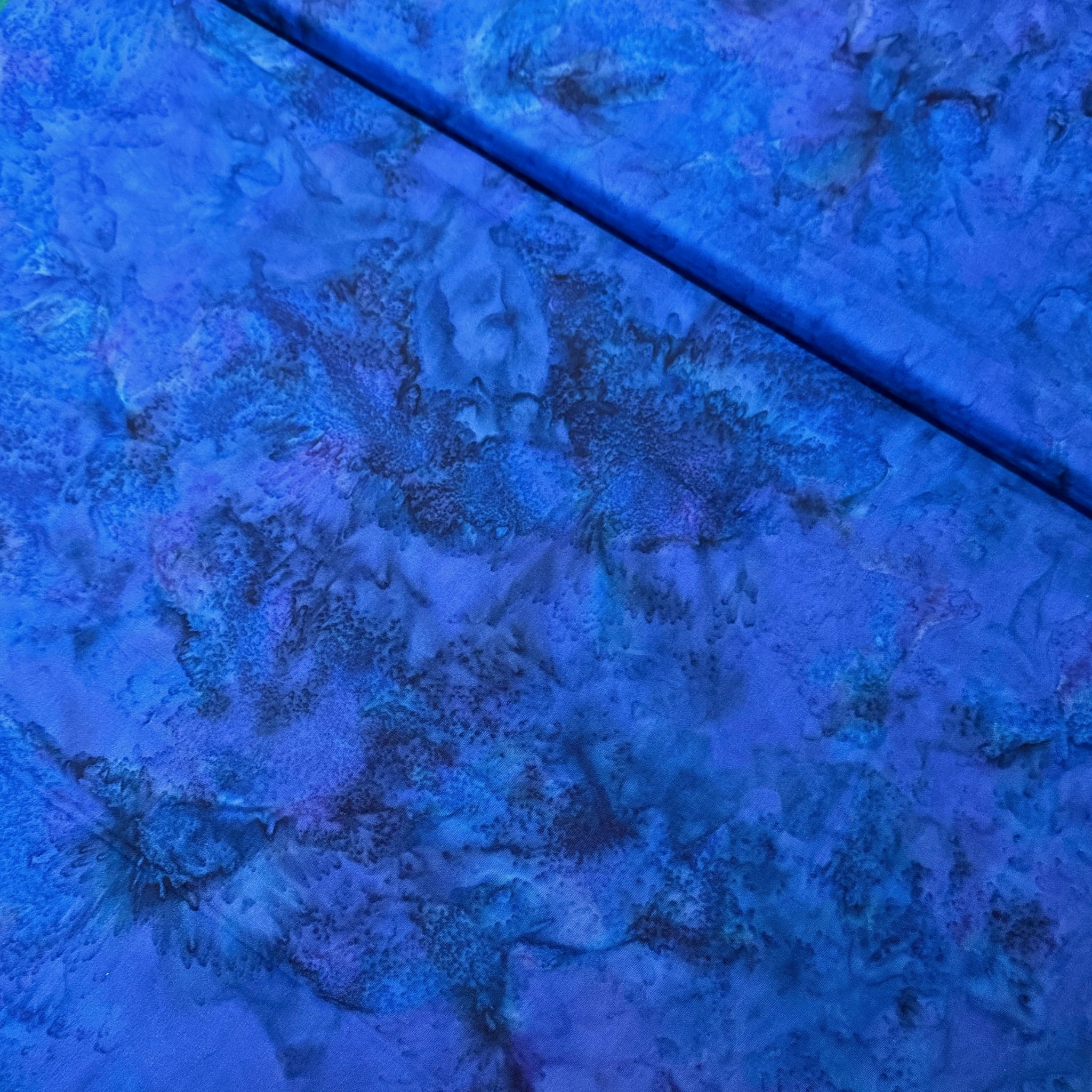 Deep violet blue mottled batik blender fabric with teal purple and navy undertones for quilt backgrounds sashing and scrappy batik quilts