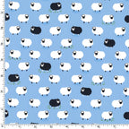 White and black sheep tossed flock blue background novelty quilting fabric for baby quilts nursery décor and children's sewing