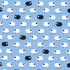 White and black sheep tossed flock blue background novelty quilting fabric for baby quilts nursery décor and children's sewing