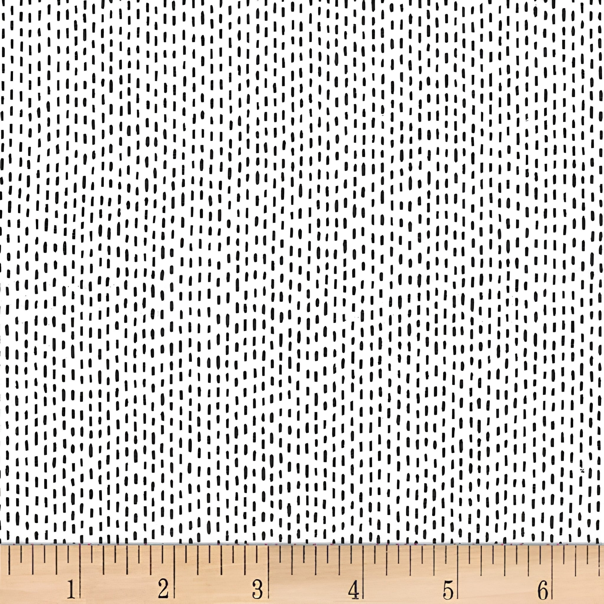 Scattered black dash stitch marks white background blender quilting fabric for backgrounds sashing baby quilts and patchwork projects