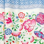 Embroidered-look floral stripe blue white fabric close-up showing printed thread detail pinks reds blues greens for quilts cushion covers and sewing projects