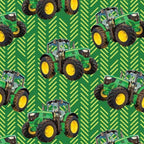 Green tractor toss fabric with patterned background, perfect for boys' quilting projects for farm lovers