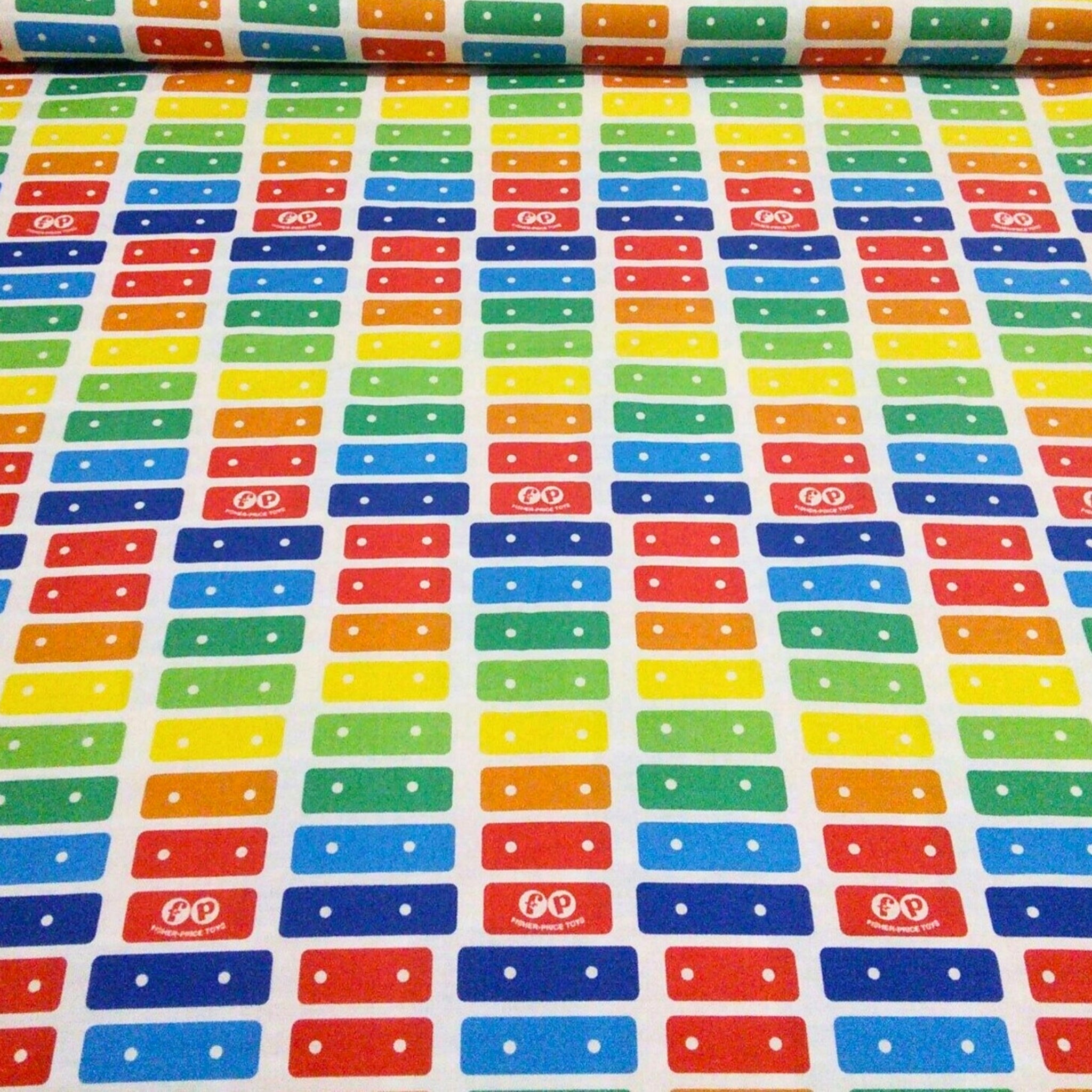 White fabric with a stripe pattern of the Fisher-Price Xylophone rainbow keys