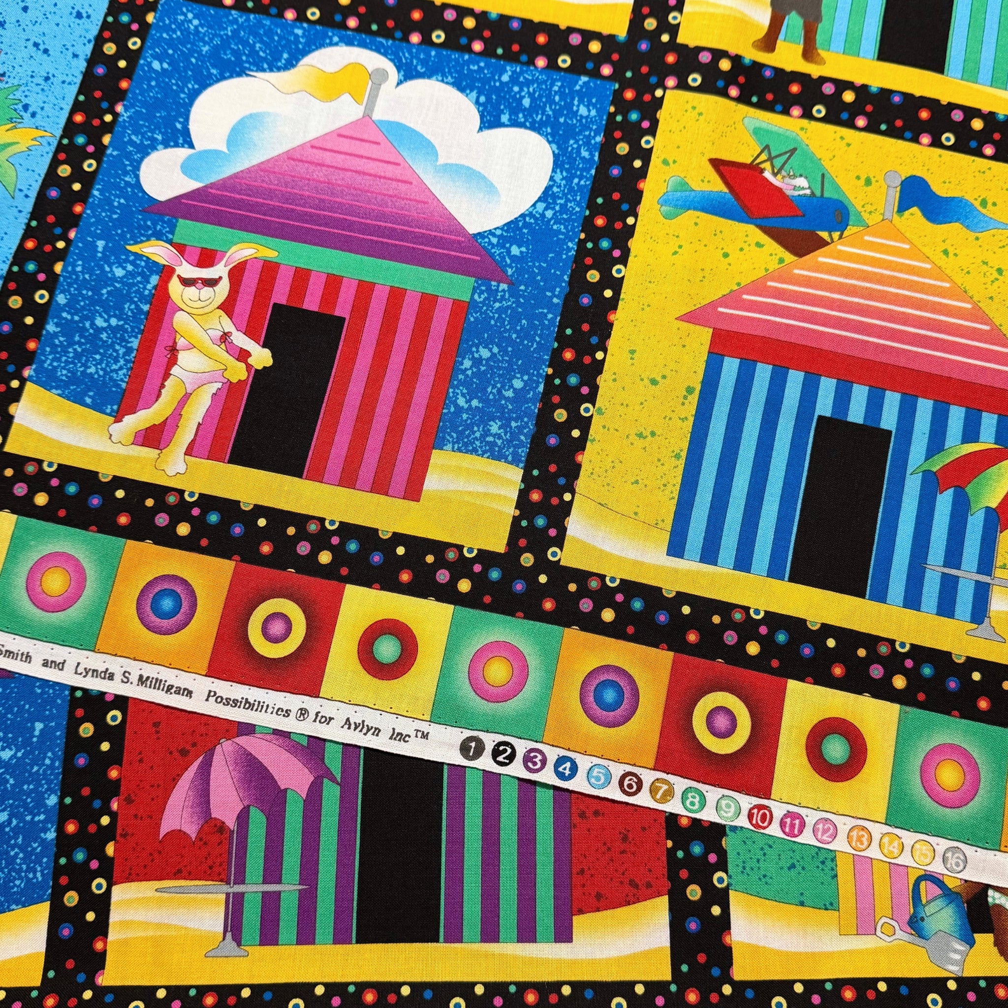 Colourful beach hut cabana tile panel close-up selvedge bunny in sunglasses circle border detail multi novelty kids beach quilts