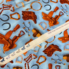 Western riding tack saddles boots horseshoes stirrups blue fabric for horse-themed quilts and equestrian patchwork sewing projects