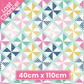Geometric pinwheel quilting cotton fabric blender in mint, pink, navy, and yellow patchwork pattern