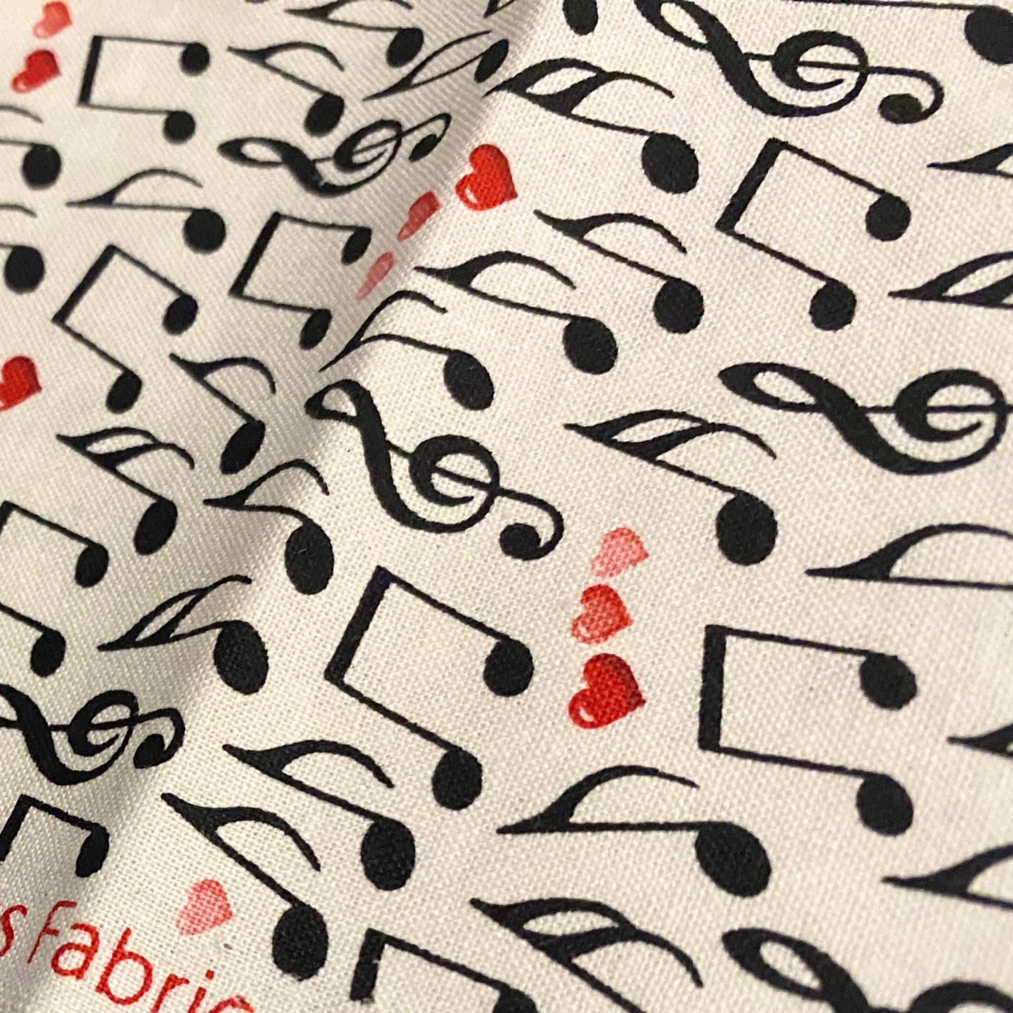 Tossed music notes treble clefs red pink hearts cream white novelty music fabric for music lovers quilts Valentine's gifts and patchwork sewing
