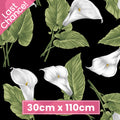 Black fabric with large tossed white calla lilies and green leaves for quilting patchwork sewing