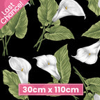Black fabric with large tossed white calla lilies and green leaves for quilting patchwork sewing
