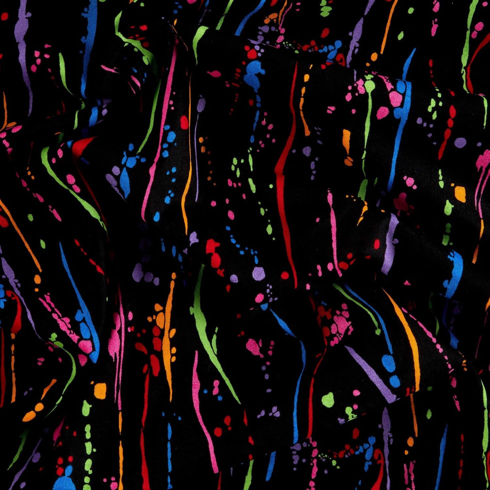 Paint splatters and drops in orange lime green blue red purple magenta on black fabric for modern quilts and patchwork sewing projects