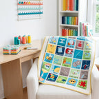 Sewing puns panel quilt blue teal yellow green draped over armchair in sewing room novelty fussy cut quilting cotton Riley Blake