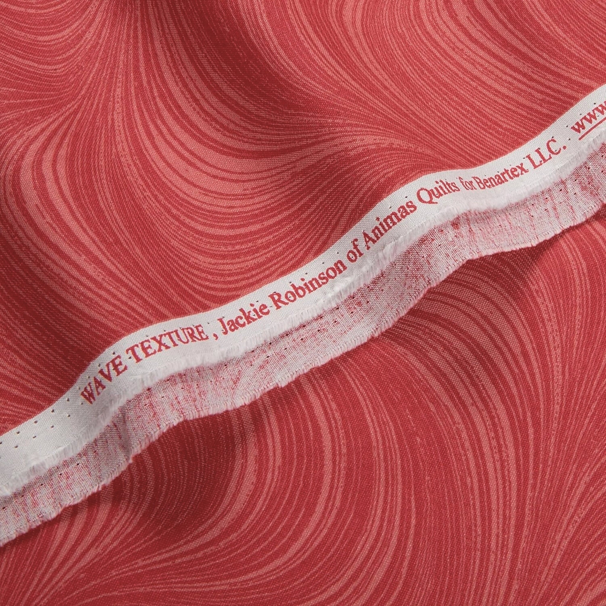 Tonal raspberry red fabric with an all-over wave and brushstroke pattern, perfect as a quilt blender