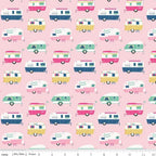 A fabric featuring a pattern of colorful vintage-style campers on a pink background, with a visible measuring scale.