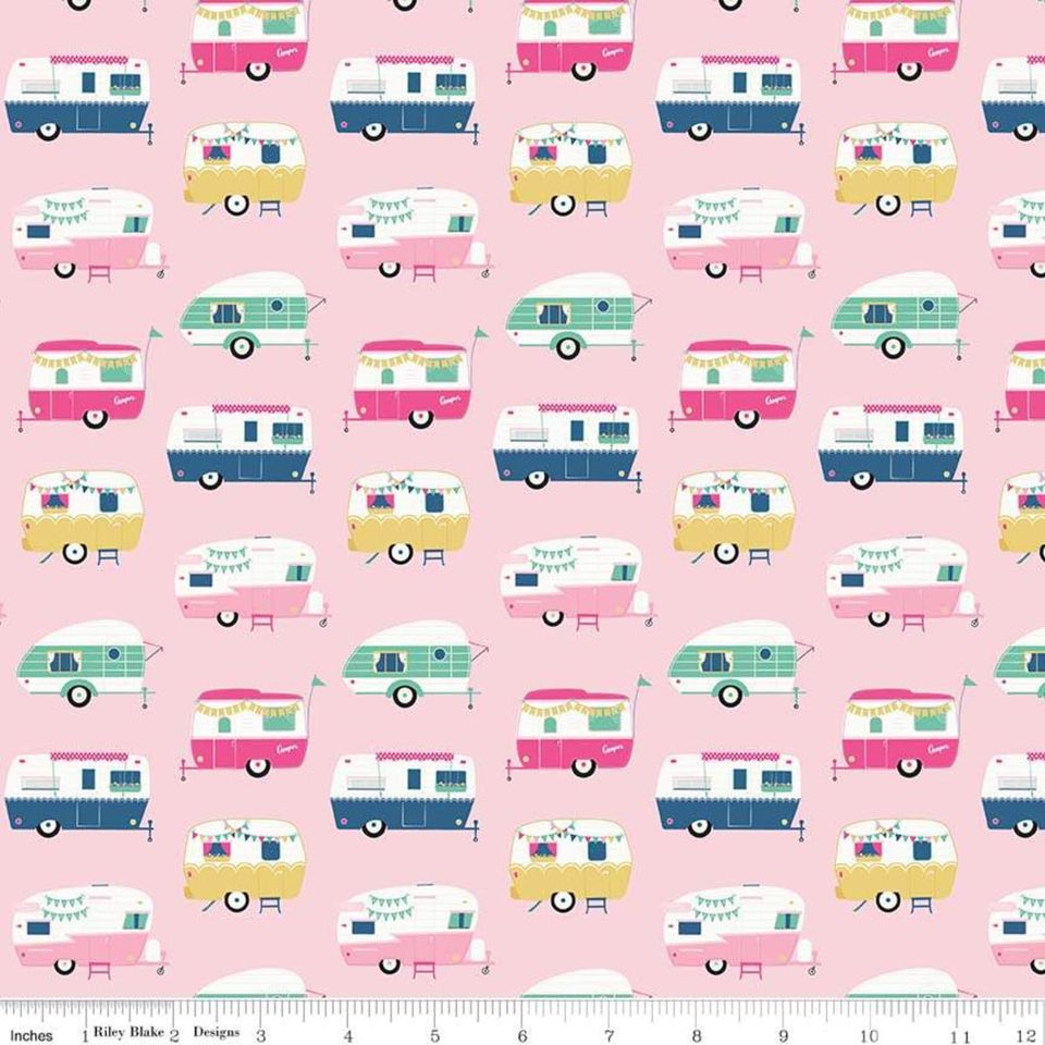 A fabric featuring a pattern of colorful vintage-style campers on a pink background, with a visible measuring scale.