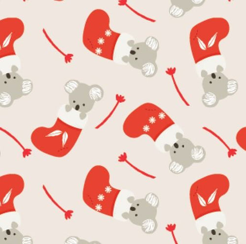Christmas quilting cotton with small tossed koalas in red stockings on cream background